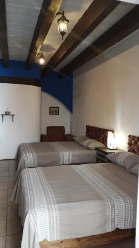 two beds in a room with blue walls at HOTEL BACANTES in Puebla