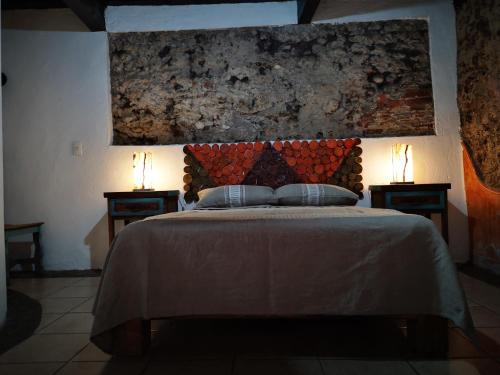 a bedroom with a bed with two lamps on two tables at HOTEL BACANTES in Puebla