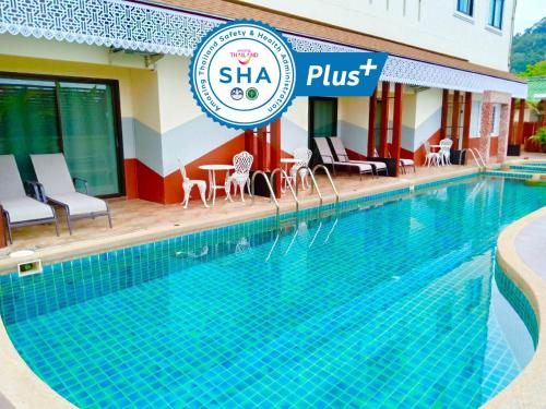 a swimming pool in front of a hotel at Mei Zhou Phuket Hotel - SHA Plus in Phuket