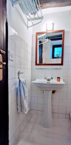 a white bathroom with a sink and a mirror at Casa independiente y completa con una habitación "Venta de Cidones" in Cidones