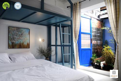 a bedroom with a bed and a large window at Aekkeko hostel in Phuket Town