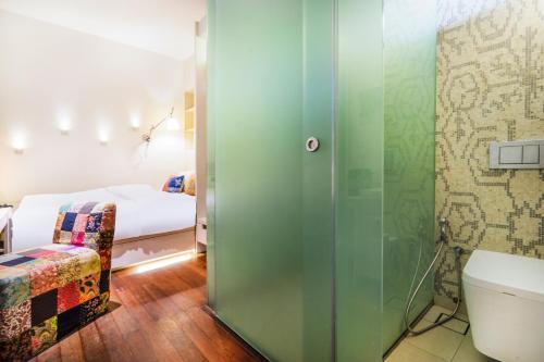 a room with a bed, a toilet and a window at The Daulat by Hotel Calmo in Singapore