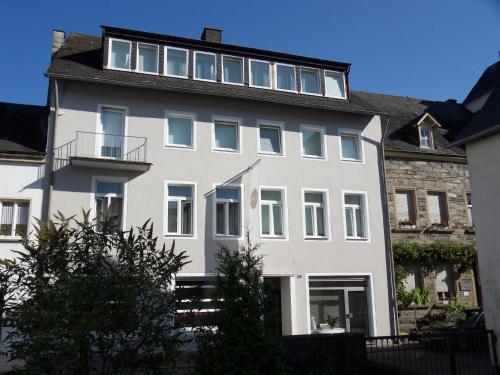 a white house with a balcony on top of it at Burgblickhotel in Bernkastel-Kues