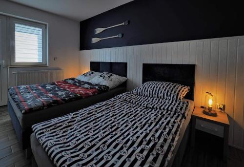 a bedroom with two beds and a table with a lamp at Serce Kaszub. Pokoje z niezależnym wejściem. in Swarzewo