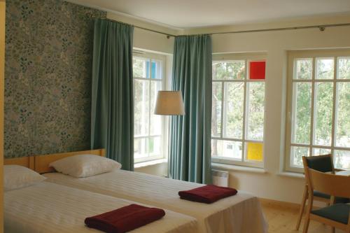 a bedroom with a bed with two red towels on it at Posti Villa in Võsu