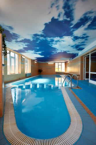 a large swimming pool with a mural of a sky at Hotel Slunce in Rýmařov