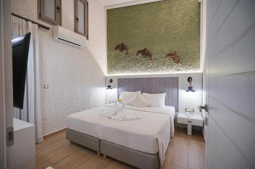 a bedroom with a bed and a painting of horses at Flamingos Hotel Apartments in Kato Daratso