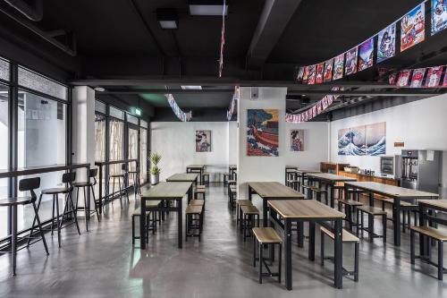 a restaurant with wooden tables and chairs in a room at Hibnb Guesthouse in Zhuangwei