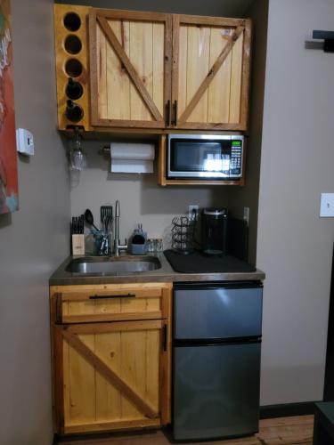 eine Küche mit einer Spüle und einer Mikrowelle in der Unterkunft The Colburn Schoolhouse - Geography suite in Sandpoint
