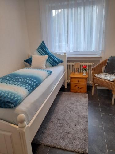 a bedroom with a bed with blue pillows and a window at Ferienwohnung Ida in Traben-Trarbach