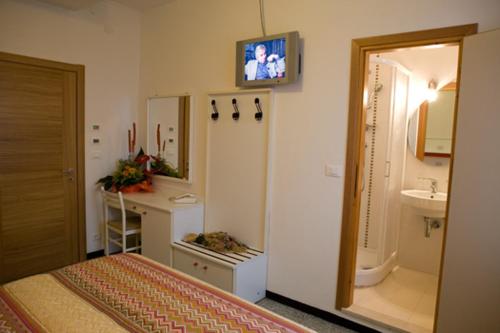una camera con letto, lavandino e specchio di Hotel Villa Ginevra a Cavallino-Treporti