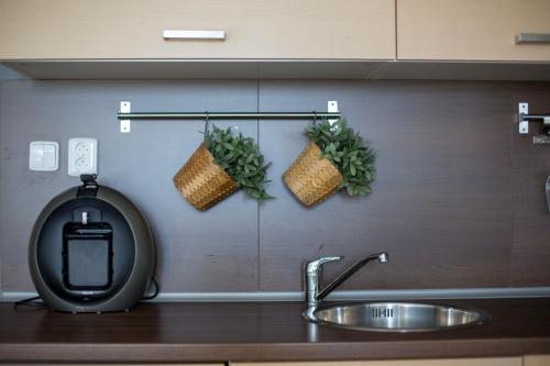 a kitchen counter with a sink and two baskets on the wall at Apartmán Angel in Veľká Lomnica