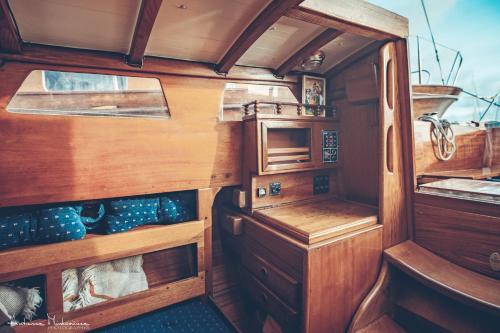 an interior of a boat with wooden walls and wooden cabinets at Yacht Matsya in Nida