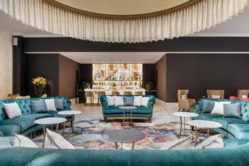 a living room with blue couches and tables at Áurea Ana Palace by Eurostars Hotel Company in Budapest