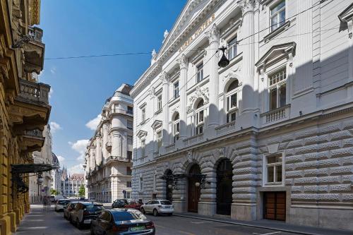 a large white building with cars parked on a street at Áurea Ana Palace by Eurostars Hotel Company in Budapest