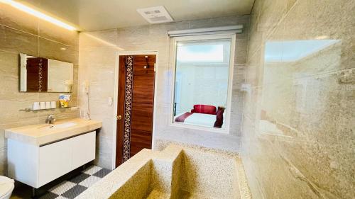 a bathroom with a sink and a toilet and a window at Jabez B&B in Jiaoxi