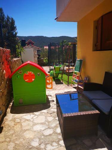 a green play house sitting in a yard at Apartmani "Mary" in Grebaštica