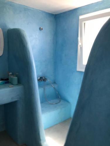 a blue room with a blue wall and a window at Anatoli in Ambelas