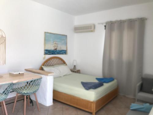 a small bedroom with a bed and a desk at Anatoli in Ambelas
