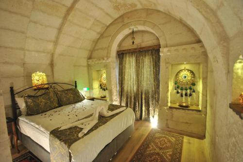 Un pat sau paturi într-o cameră la Hotel Elvan Cave House