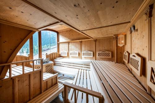 una grande stanza con pavimento in legno e panche di MANNI das Hotel a Mayrhofen