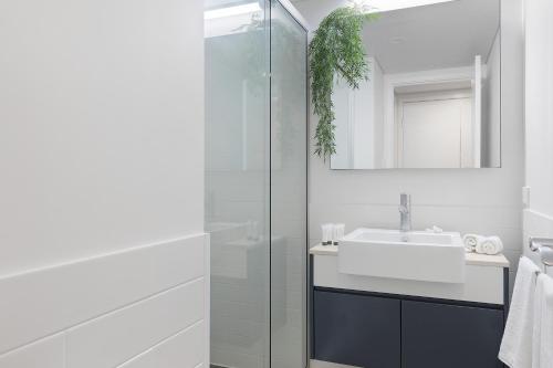 a white bathroom with a sink and a shower at Azure Sea Whitsunday Resort in Airlie Beach