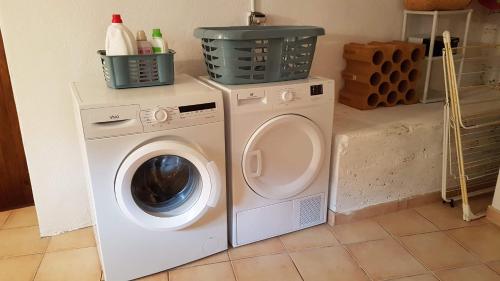 a washing machine and a washer in a laundry room at Maison au cœur des Pyrénées in Perles-et-Castelet