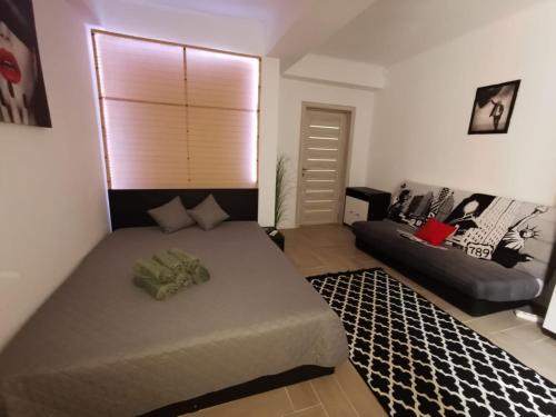 1 dormitorio con 1 cama grande y 1 sofá en Garsoniera D14, en Mamaia Nord – Năvodari