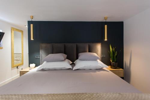 a bedroom with a large white bed with two pillows at Castel Beachfront Apartment in Kaštela