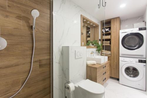 a bathroom with a toilet and a washer and dryer at Castel Beachfront Apartment in Kaštela
