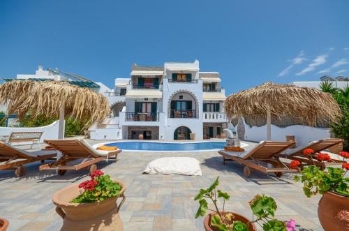 un complejo con piscina, sillas y un edificio en Orama Apartments, en Agia Anna de Naxos