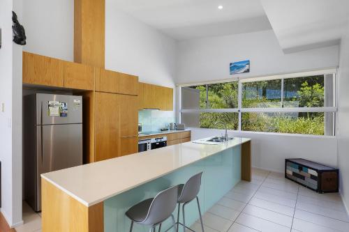 a kitchen with a counter and a refrigerator at Azure Sea Whitsunday Resort in Airlie Beach