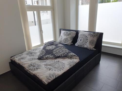 1 cama con almohadas en una habitación con ventanas en Schönes Studio in Arbon am Bodensee Neu Klimatisiert !, en Arbon