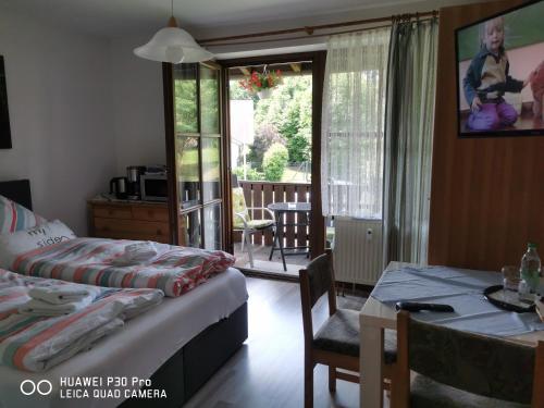 a bedroom with a bed and a table and a table and chairs at Aparthotel-Chrysantihof - Aleksandra in Zwiesel