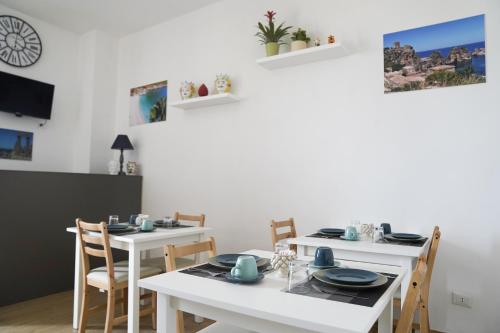 jadalnia z dwoma białymi stołami i krzesłami w obiekcie B&B Socrate w mieście Agrigento