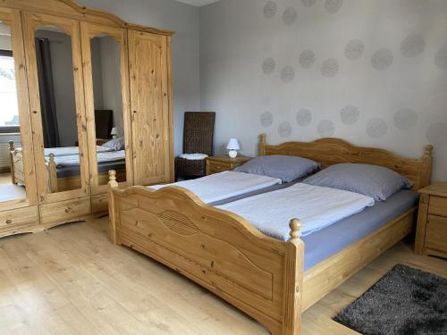 um quarto com uma cama de madeira e um espelho em Ferienwohnung Sonnenschein em Bad Hersfeld
