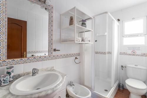 een witte badkamer met een wastafel en een toilet bij Casita Puente Viejo in Nerja