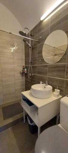 a bathroom with a sink and a mirror and a toilet at LUNA in Oradea
