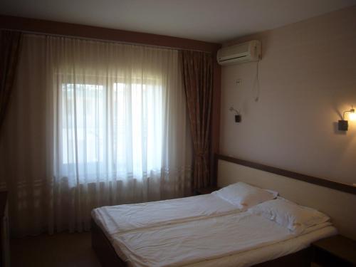 エフォリエ・ノルドにあるVila Dodaのベッドルーム1室(ベッド1台付)、窓(白いシーツ付)