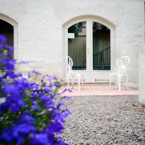 two white chairs sitting in front of a door at Hotel Hellstens Malmgård in Stockholm