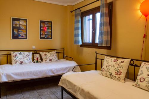 1 dormitorio con 2 camas y ventana en Seaview Maisonette, en Ierissos