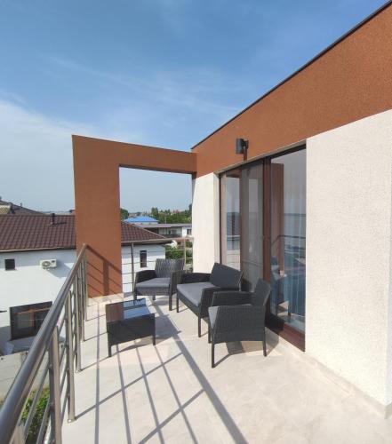 a balcony with chairs and tables on a building at Villa Orchidea Sunrise in Zatoka
