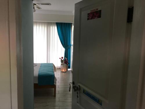 a door to a bedroom with a bed and a window at Mola Hotel in Marmara Adasi