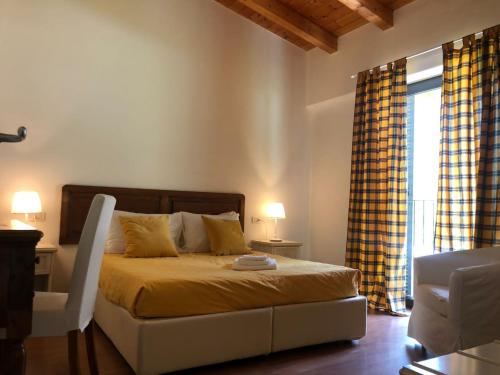 ein Schlafzimmer mit einem Bett mit gelber Bettwäsche und einem Fenster in der Unterkunft Residence i Fiori in Piantedo