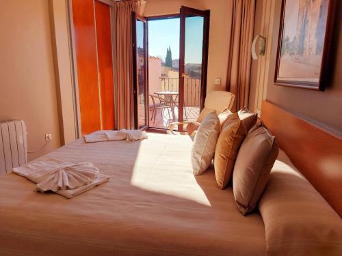 a large bed in a room with a large window at HOTEL RURAL San Pedro in Frómista