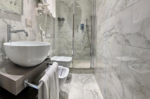 W łazience znajduje się umywalka, toaleta i prysznic. w obiekcie Hotel Lamberti w Alassio