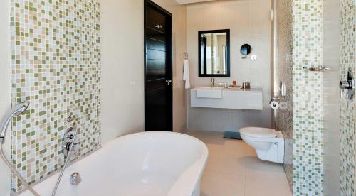 ein Badezimmer mit einer Badewanne, einem WC und einem Waschbecken in der Unterkunft The Oasis in Upington