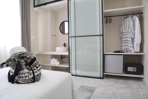 a room with a bed and a glass closet at OIKO MINI SUITES in Ermoupoli