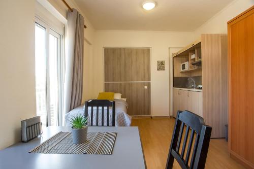 a living room with a table and a room with a bed at Rea Hotel in Faliraki