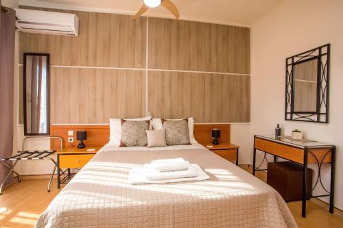 a bedroom with a large bed and a desk at Rea Hotel in Faliraki